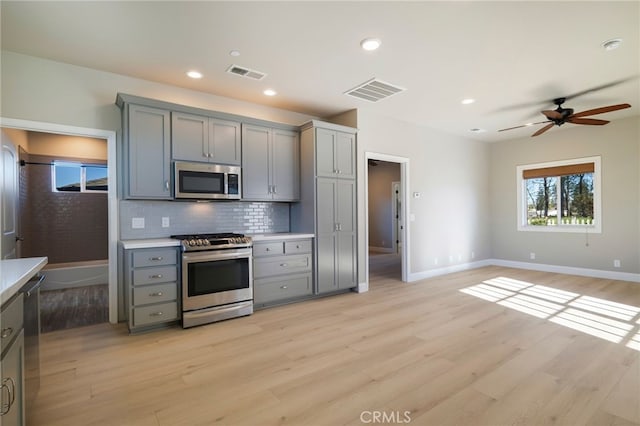 766 Willow St, Paradise, CA 95969 - kitchen featuring stainless steel appliances, gray cabinetry, light wood-style flooring, tasteful backsplash, and a ceiling fan