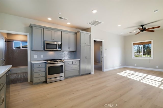 766 Willow St, Paradise, CA 95969 - kitchen with appliances with stainless steel finishes, gray cabinetry, light wood-style flooring, tasteful backsplash, and ceiling fan