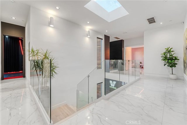 hall with marble finish floor, recessed lighting, a skylight, and visible vents