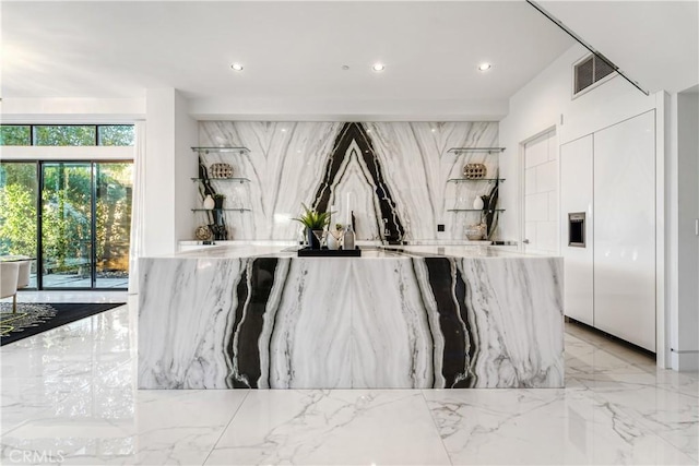 bar with stone wall, marble finish floor, and recessed lighting