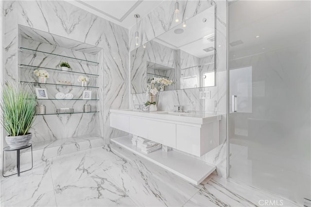 full bathroom featuring stone wall, vanity, a marble finish shower, and tile walls