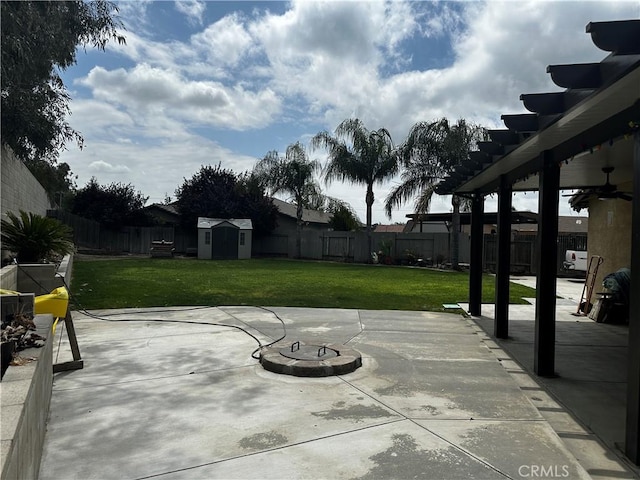 view of patio / terrace featuring an outdoor structure, a ceiling fan, a storage unit, and a fenced backyard