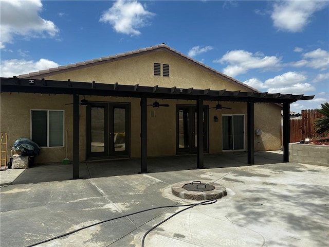 back of house featuring a patio area, an outdoor fire pit, a ceiling fan, stucco siding, and fence