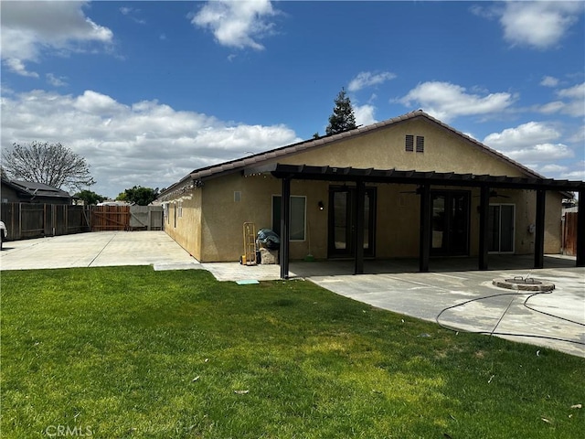 rear view of property featuring ceiling fan, stucco siding, a fenced backyard, and a patio area