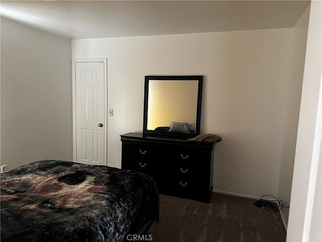 bedroom featuring baseboards and dark colored carpet