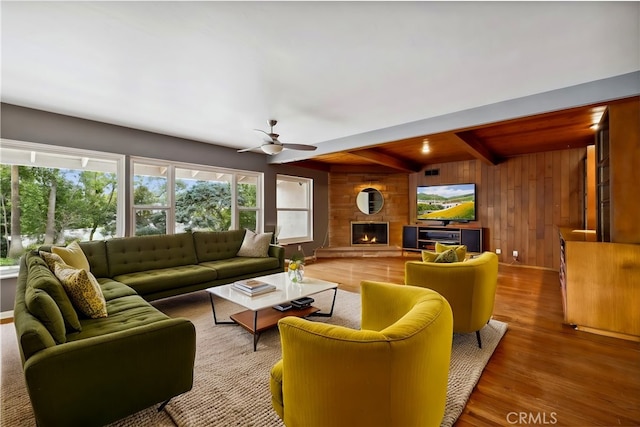 4254 Miramonte Pl, Riverside, CA 92501 - living area with wood walls, a ceiling fan, wood finished floors, a fireplace, and beamed ceiling