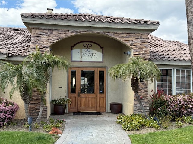 375 Central Ave Unit 12, Riverside, CA 92507 - view of exterior entry with stucco siding, stone siding, and a tiled roof