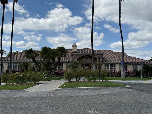375 Central Ave Unit 12, Riverside, CA 92507 - mediterranean / spanish-style house featuring stucco siding, a tiled roof, and a chimney