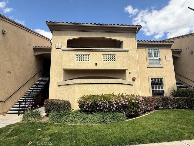 375 Central Ave Unit 12, Riverside, CA 92507 - view of home's exterior featuring stairs, stucco siding, and a lawn