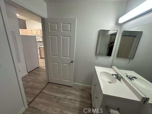375 Central Ave Unit 12, Riverside, CA 92507 - bathroom with wood finished floors, vanity, and baseboards