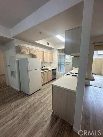 375 Central Ave Unit 12, Riverside, CA 92507 - kitchen featuring freestanding refrigerator, light wood-type flooring, light countertops, stainless steel dishwasher, and a tray ceiling