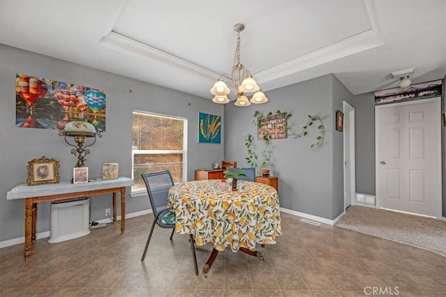 dining room with ornamental molding, a raised ceiling, a notable chandelier, and baseboards