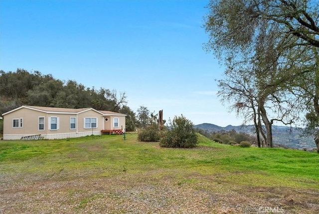 view of front of property featuring a front lawn and a mountain view