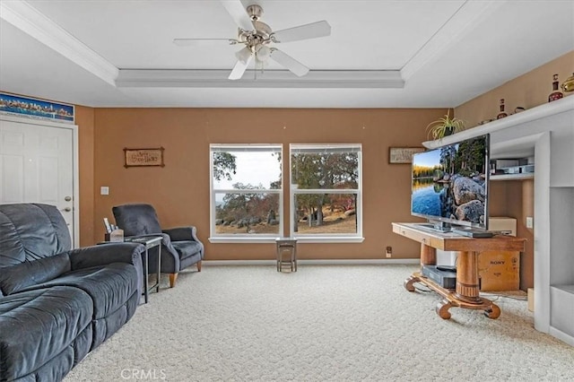 carpeted living area with a ceiling fan, a tray ceiling, baseboards, and crown molding