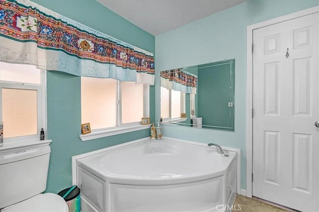 bathroom with toilet, tile patterned flooring, and a bath