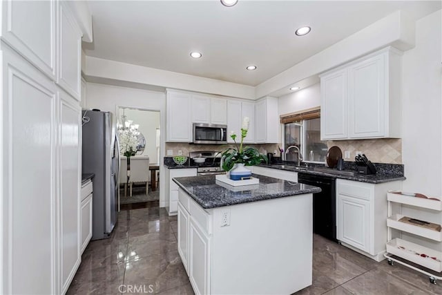kitchen featuring tasteful backsplash, a kitchen island, white cabinetry, and stainless steel appliances