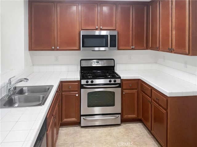 15605 Lasselle St Unit 6, Moreno Valley, CA 92551 - kitchen featuring appliances with stainless steel finishes, a sink, tile counters, and light tile patterned floors