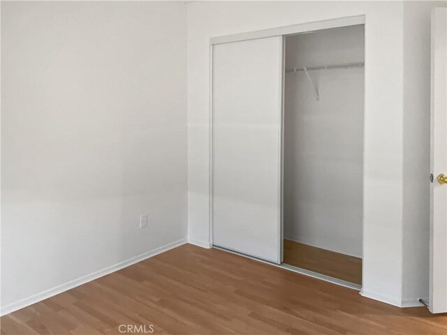 15605 Lasselle St Unit 6, Moreno Valley, CA 92551 - unfurnished bedroom with a closet, wood finished floors, and baseboards