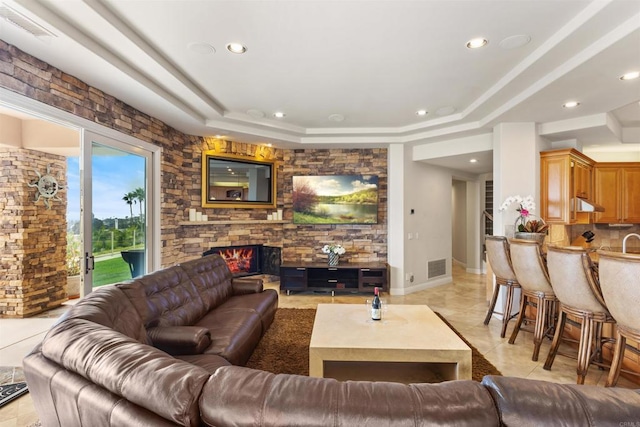 5023 Windsor Dr, San Diego, CA 92109 - living room with recessed lighting, light tile patterned floors, a stone fireplace, and a tray ceiling