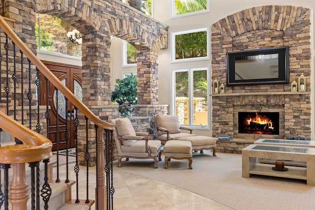 5023 Windsor Dr, San Diego, CA 92109 - carpeted living area with a towering ceiling, stairway, a stone fireplace, and tile patterned floors