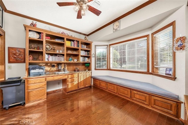41504 Mission Dr, Palmdale, CA 93551 - home office featuring ornamental molding, built in desk, ceiling fan, vaulted ceiling, and dark wood-style floors