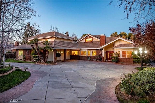 41504 Mission Dr, Palmdale, CA 93551 - view of front of property featuring a chimney, curved driveway, stucco siding, and a tile roof