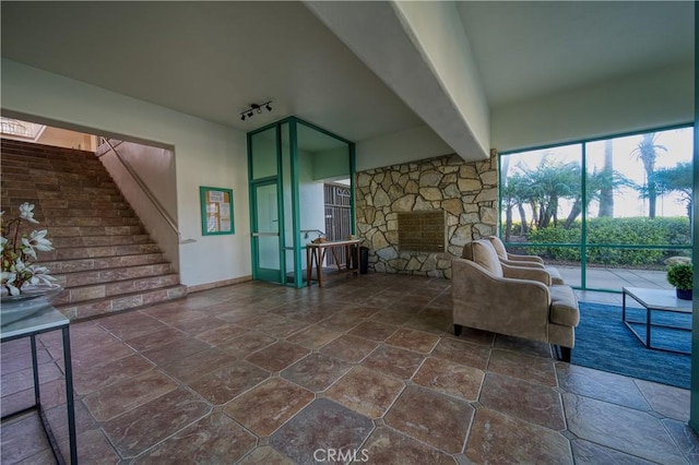 201 Calle Miramar Unit 16, Redondo Beach, CA 90277 - living area with dark stone finish floors, a stone fireplace, and stairs