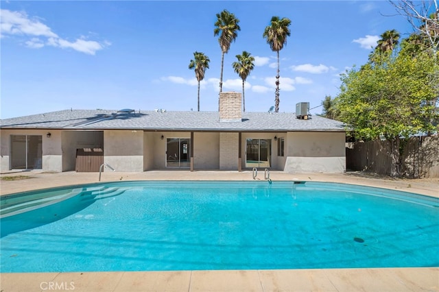 outdoor pool featuring fence and central AC unit