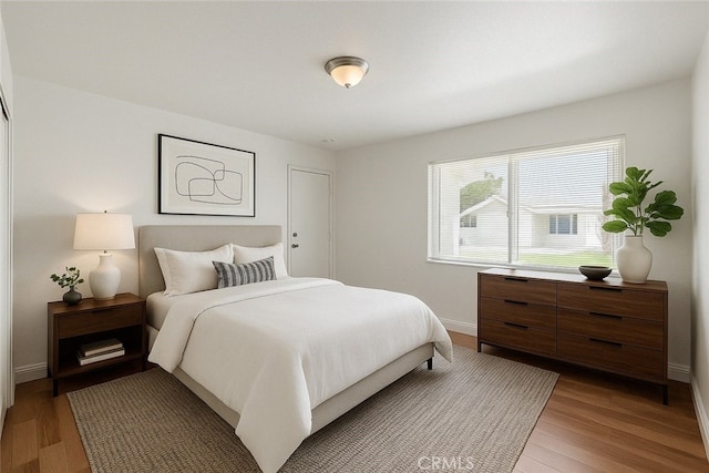 bedroom featuring light wood-style flooring and baseboards