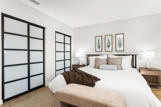 bedroom with visible vents and wood finished floors