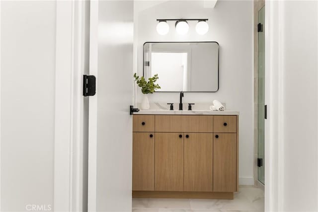 bathroom featuring marble finish floor, vanity, and a shower stall