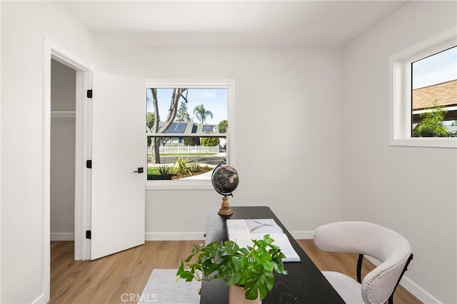 home office with plenty of natural light, baseboards, and wood finished floors