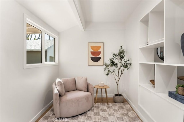 living area with lofted ceiling with beams and baseboards