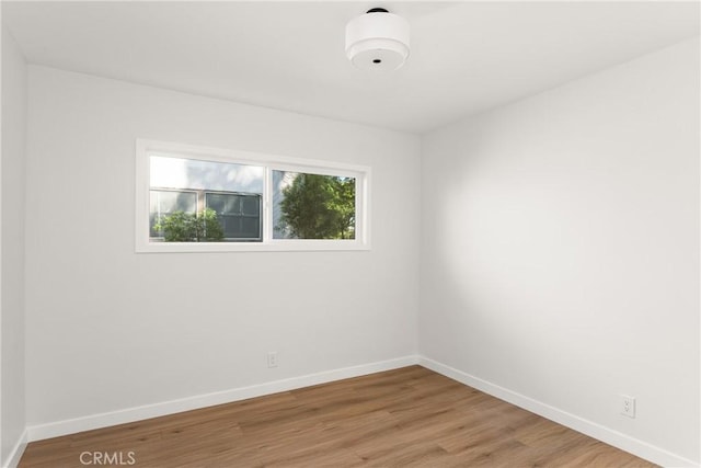 empty room with baseboards and wood finished floors