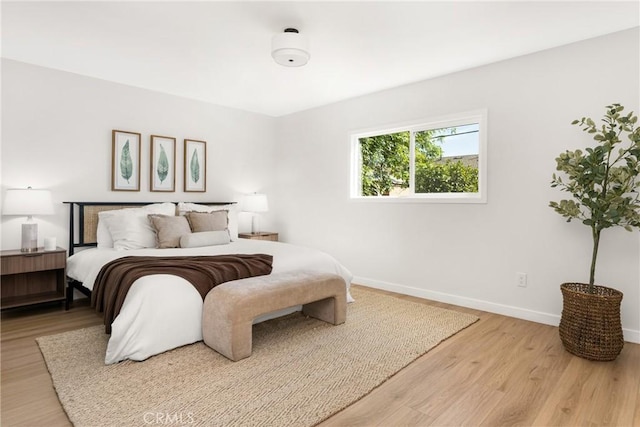 bedroom with baseboards and wood finished floors