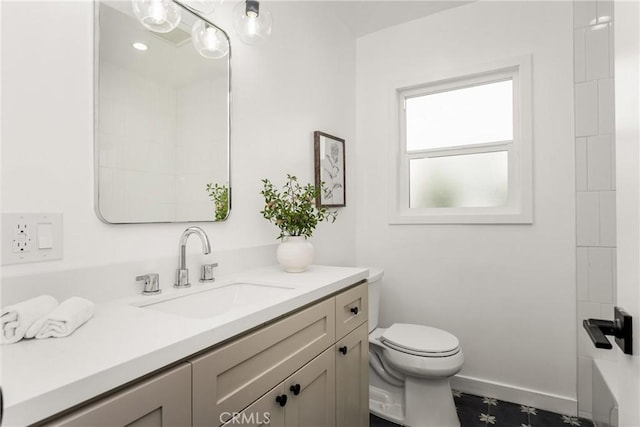 bathroom with baseboards, toilet, and vanity