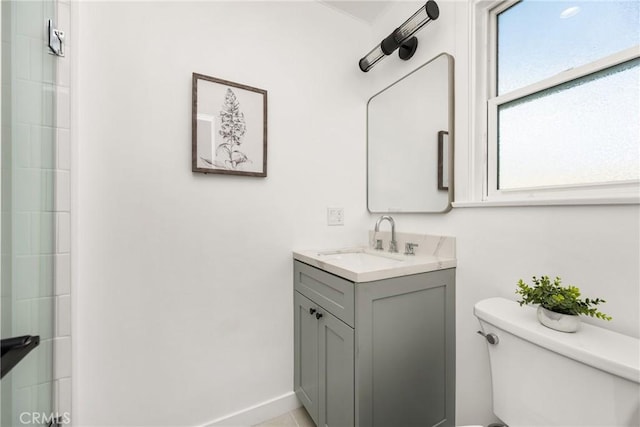 full bathroom with baseboards, toilet, a shower, and vanity