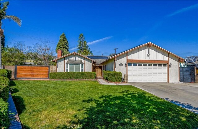 view of front of home featuring concrete driveway, fence, board and batten siding, a gate, and roof mounted solar panels