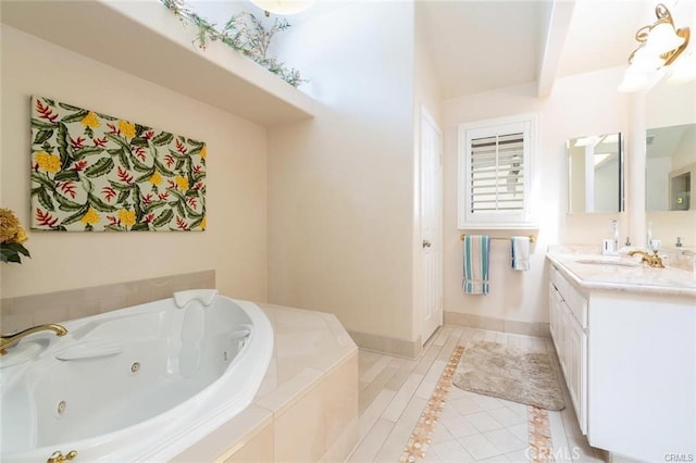 bathroom featuring tile patterned floors, vanity, a jetted tub, and baseboards