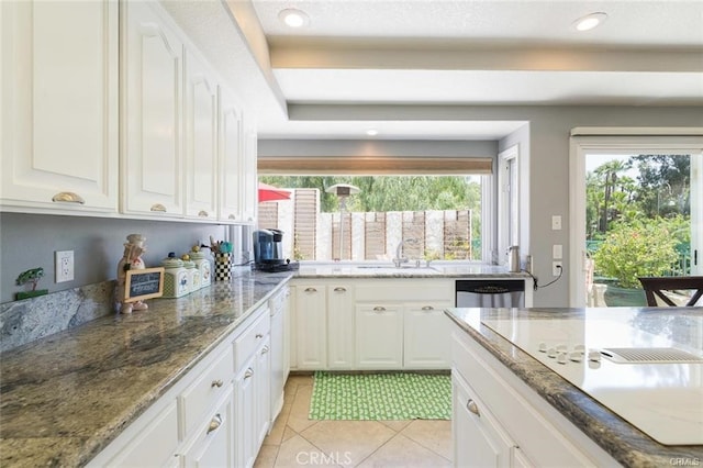 kitchen featuring white cabinets, dishwasher, a sink, stone countertops, and light tile patterned floors