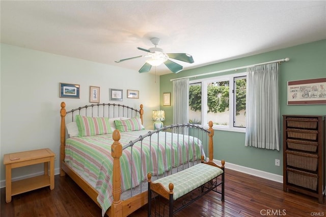 bedroom featuring baseboards, wood finished floors, and ceiling fan