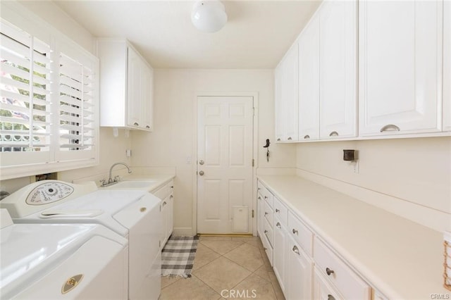 clothes washing area with light tile patterned flooring, separate washer and dryer, cabinet space, and a sink