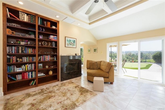 living area featuring coffered ceiling, ornamental molding, beam ceiling, a high end fireplace, and a ceiling fan