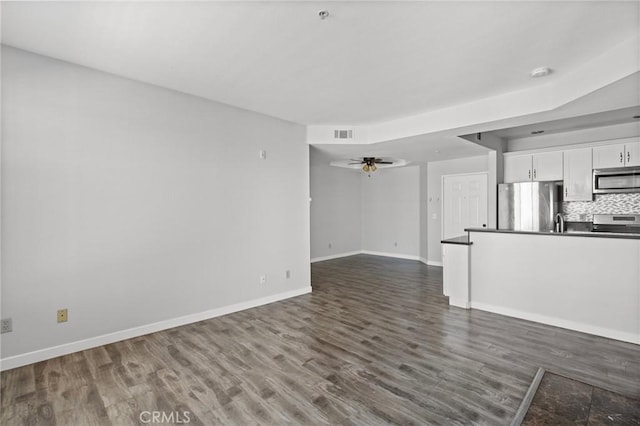 unfurnished living room with visible vents, baseboards, a ceiling fan, and dark wood finished floors
