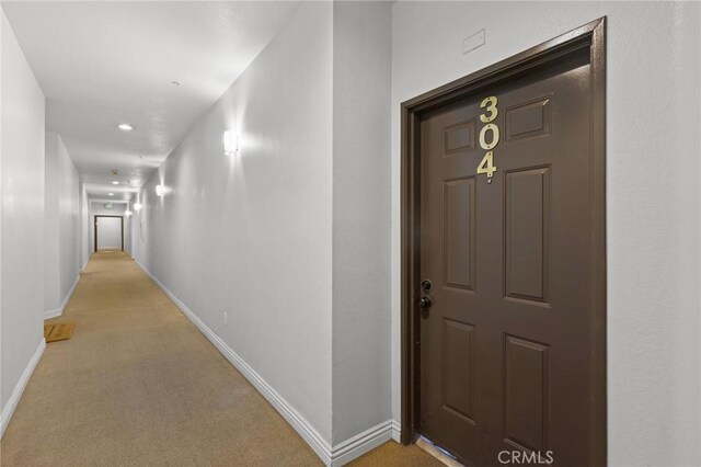 hall with light carpet, recessed lighting, and baseboards