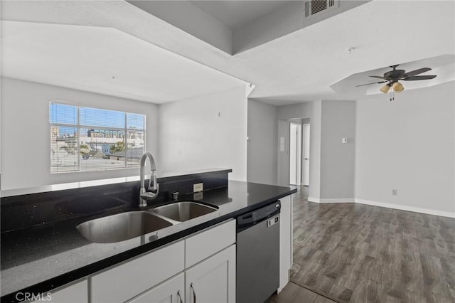 kitchen featuring visible vents, white cabinets, a sink, dark countertops, and stainless steel dishwasher