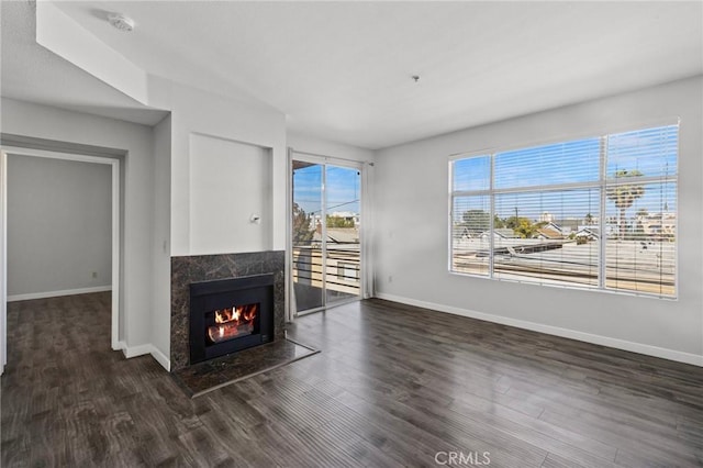 unfurnished living room featuring wood finished floors, a fireplace, and baseboards