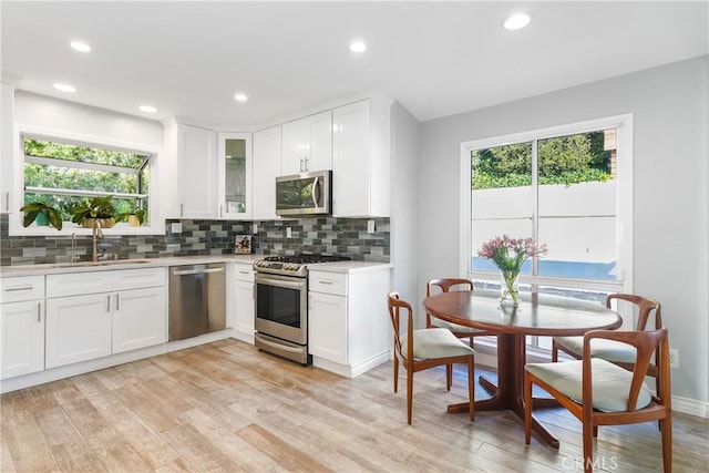 410 Via Mesa Grande, Redondo Beach, CA 90277 - kitchen with appliances with stainless steel finishes, a sink, light countertops, light wood-type flooring, and backsplash