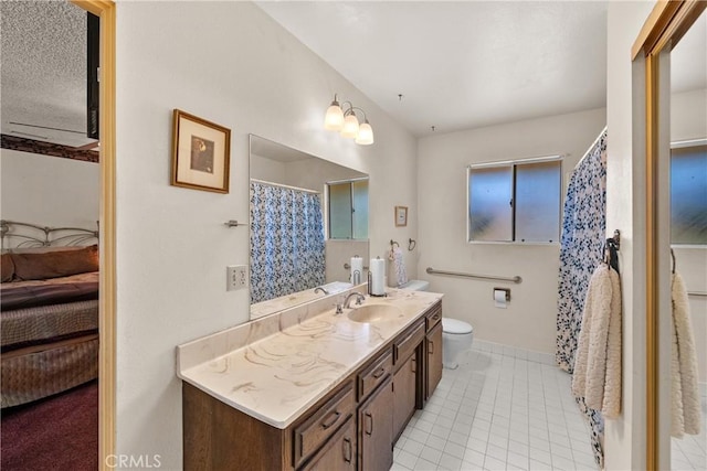 full bath with tile patterned floors, toilet, vanity, ensuite bathroom, and baseboards