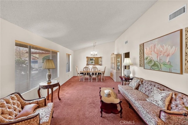 carpeted living room with a textured ceiling, lofted ceiling, a chandelier, and visible vents